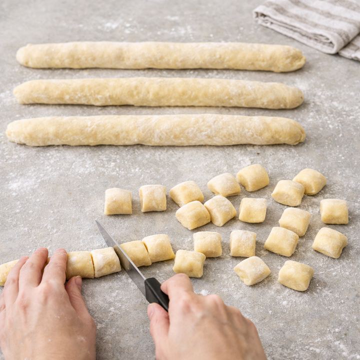 Pale yellow potato dough rolled into ropes and cut into pieces
